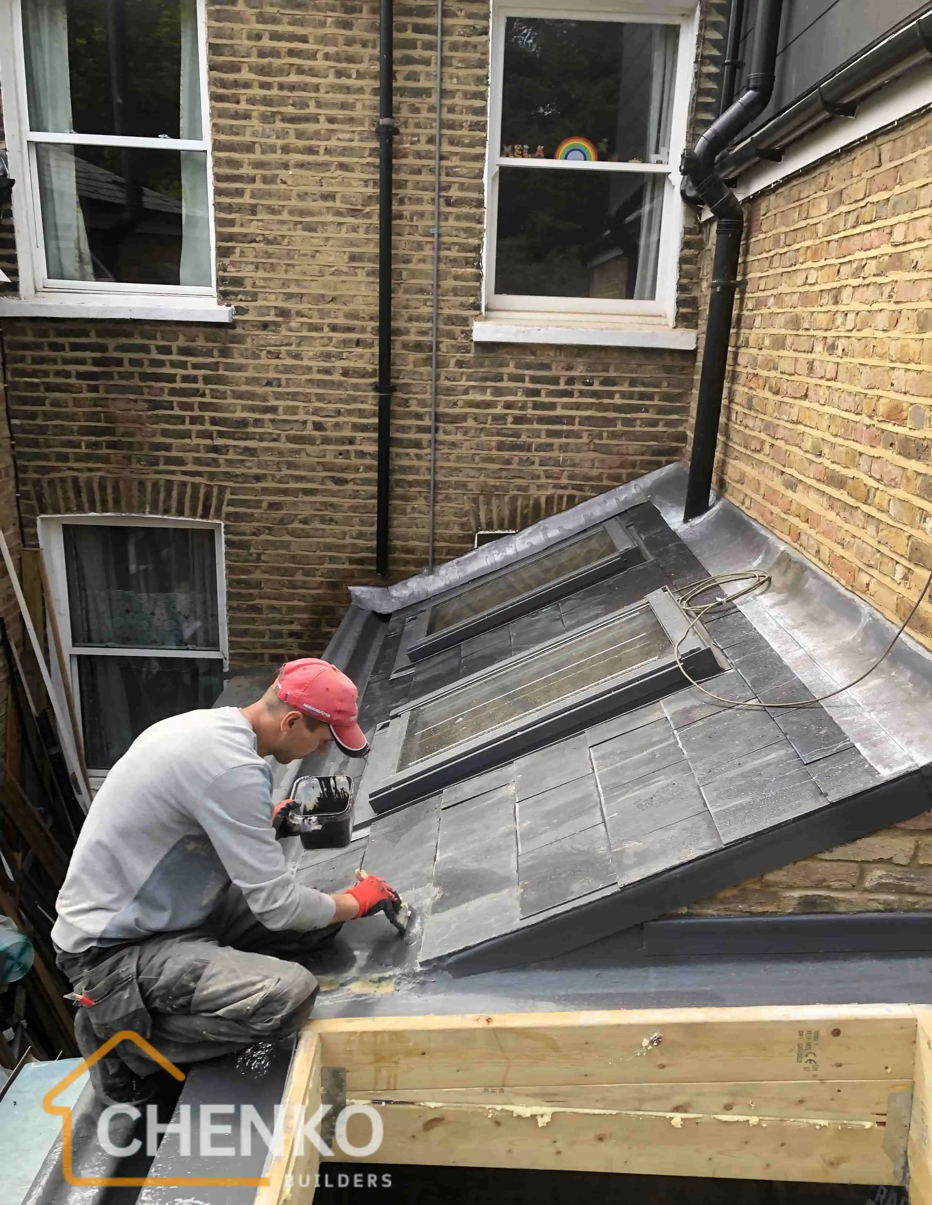 Builder working on extension roof with skylight
